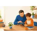 Vader en kind gebruiken samen een tablet aan tafel in een huiselijke omgeving.
